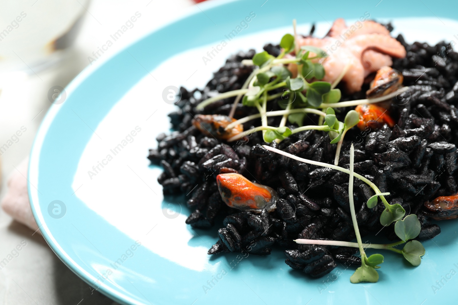 Photo of Delicious black risotto with seafood in plate, closeup