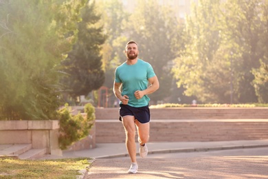 Young man running in park on sunny day