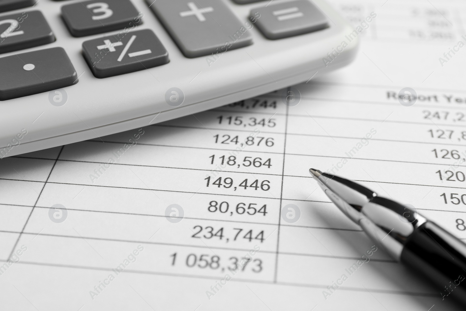 Photo of Calculator and pen on documents, closeup view