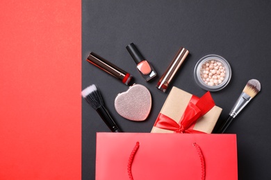 Photo of Flat lay composition with makeup products and gift box on color background