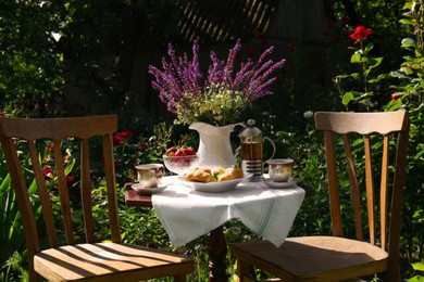 Photo of Beautiful bouquet of wildflowers on table served for tea drinking in garden