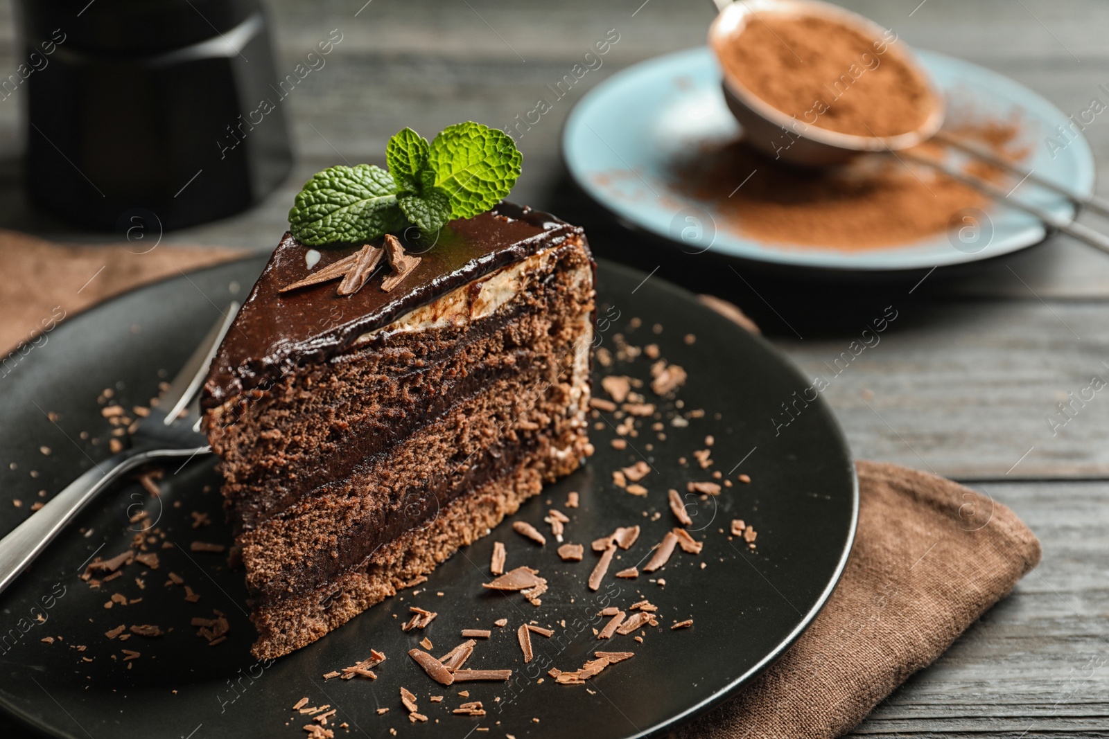 Photo of Plate with slice of chocolate cake and fork on table