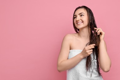 Photo of Young woman applying hair mask on pink background. Space for text