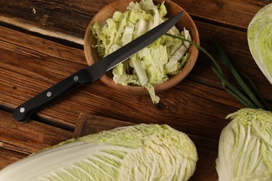 Photo of Whole and cut fresh Chinese cabbages on wooden table