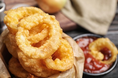 Photo of Dishware with homemade crunchy fried onion rings and sauce, closeup