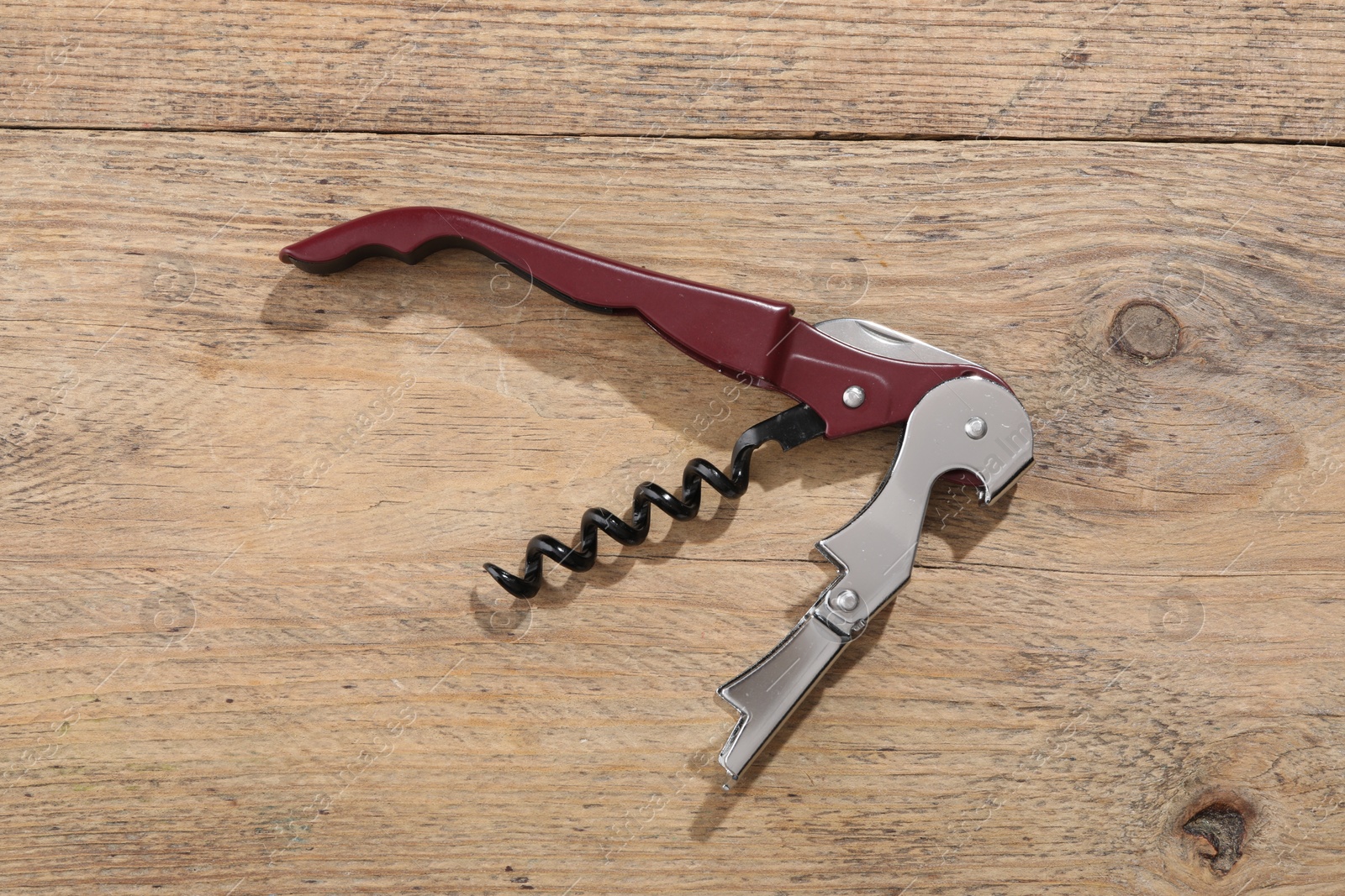 Photo of One corkscrew (sommelier knife) on wooden table, top view