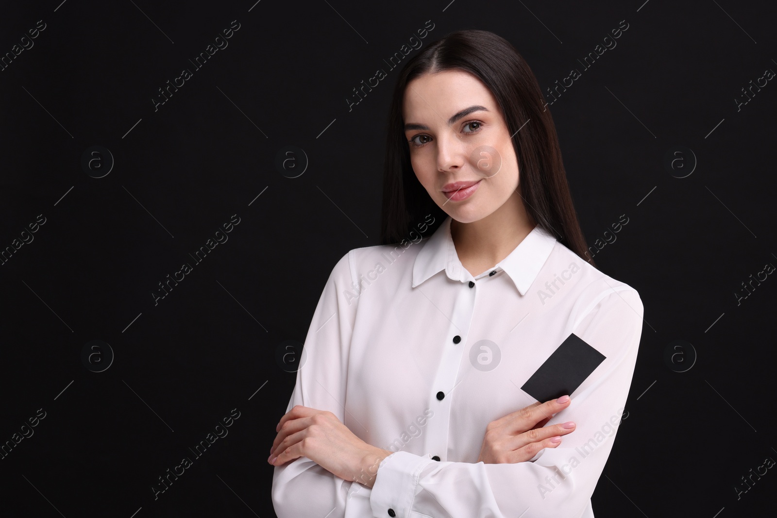 Photo of Woman holding blank business card on black background. Space for text