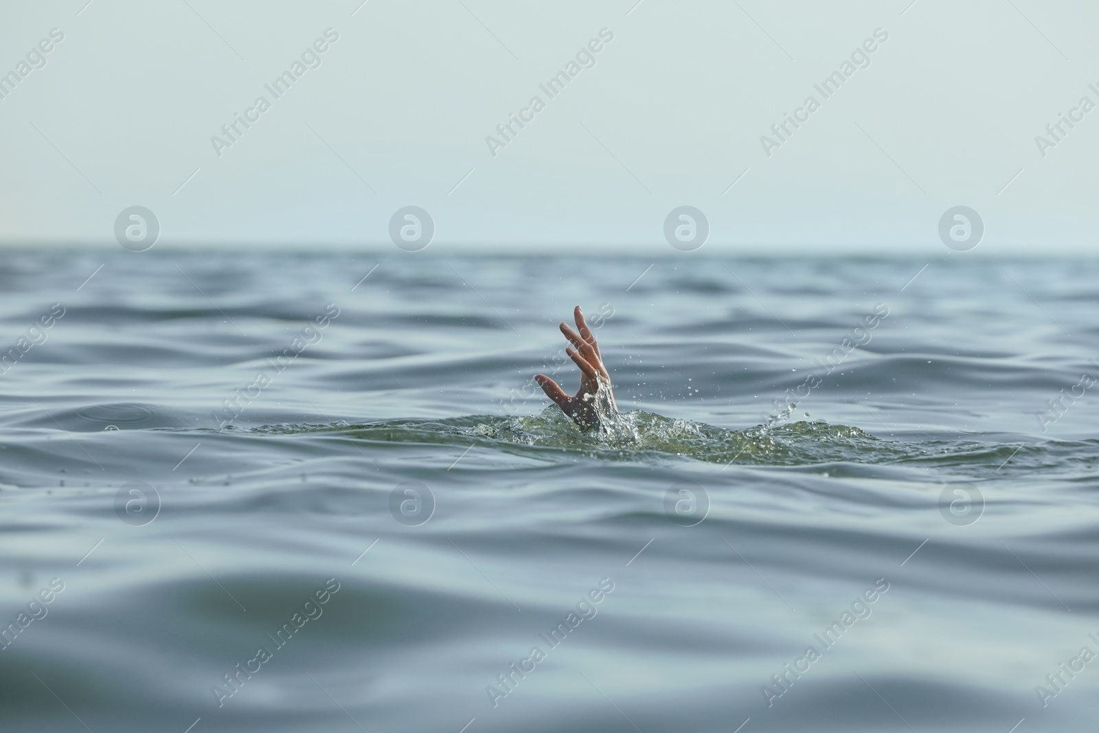 Photo of Drowning woman reaching for help in sea