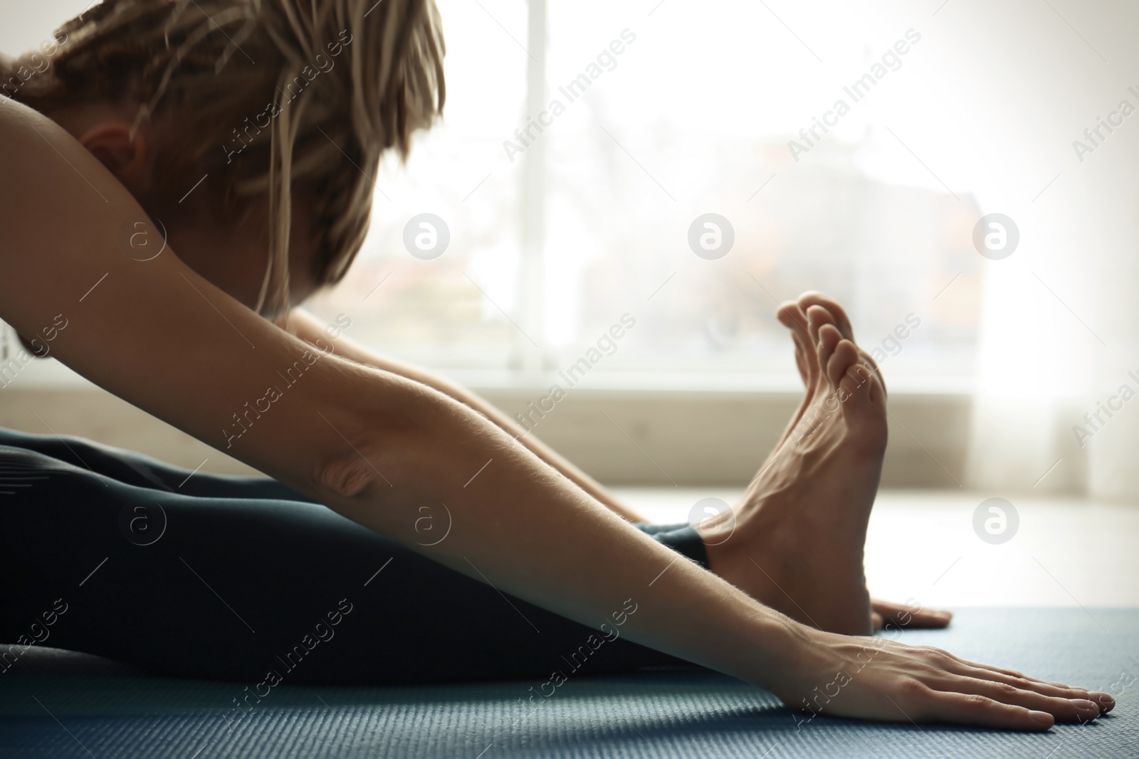 Photo of Young woman practicing yoga indoors