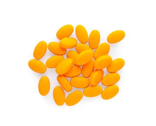 Tasty orange dragee candies on white background, top view