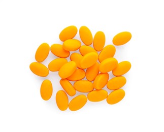 Photo of Tasty orange dragee candies on white background, top view