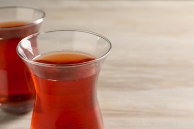 Glasses of traditional Turkish tea on white table, closeup. Space for text