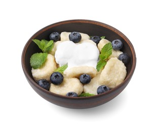 Photo of Bowl of tasty lazy dumplings with blueberries, mint leaves and sour cream isolated on white