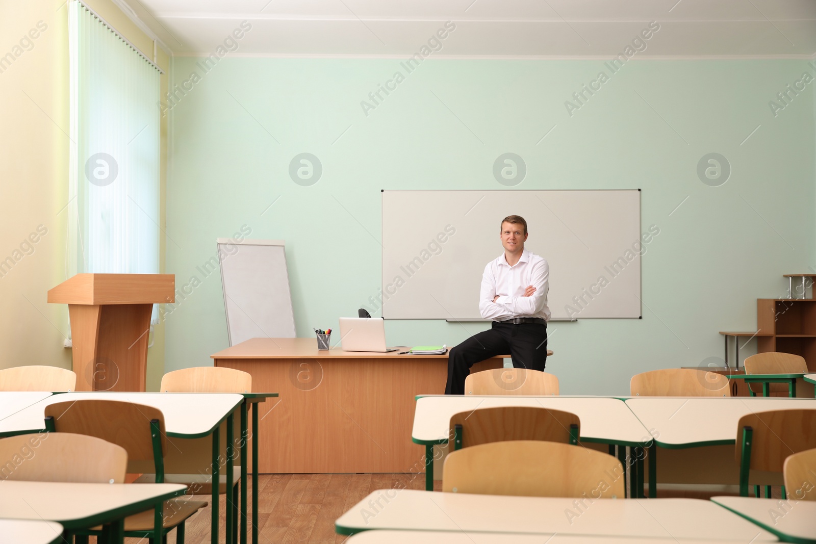 Photo of Portrait of male teacher in modern classroom