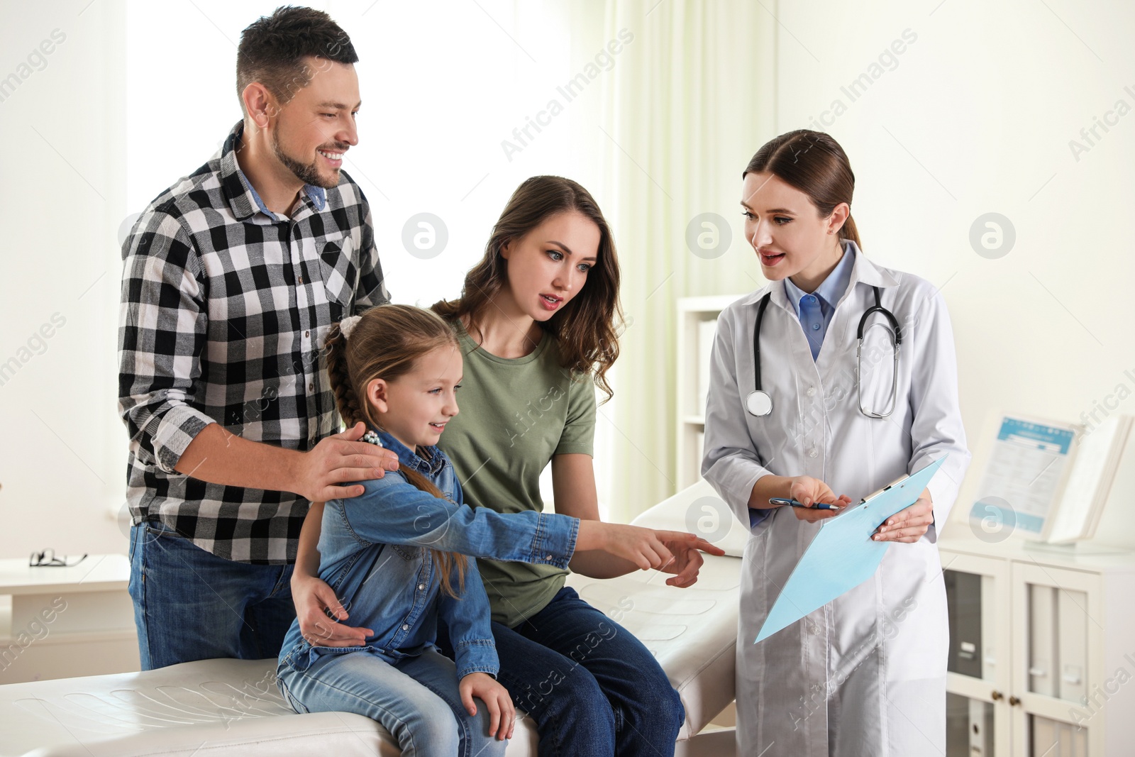 Photo of Parents and daughter visiting pediatrician. Doctor working with patient in hospital