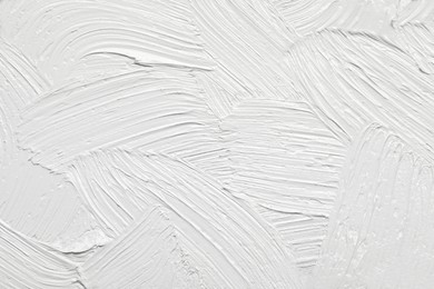 Photo of Strokes of white oil paint as background, closeup