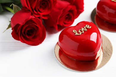 Photo of St. Valentine's Day. Delicious heart shaped cake and beautiful roses on white table, closeup