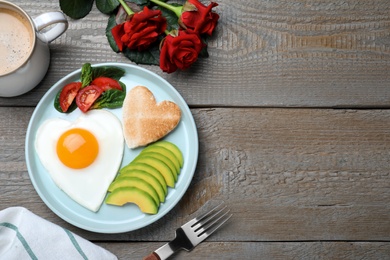 Photo of Romantic breakfast and roses on wooden table, flat lay with space for text. Valentine's day celebration