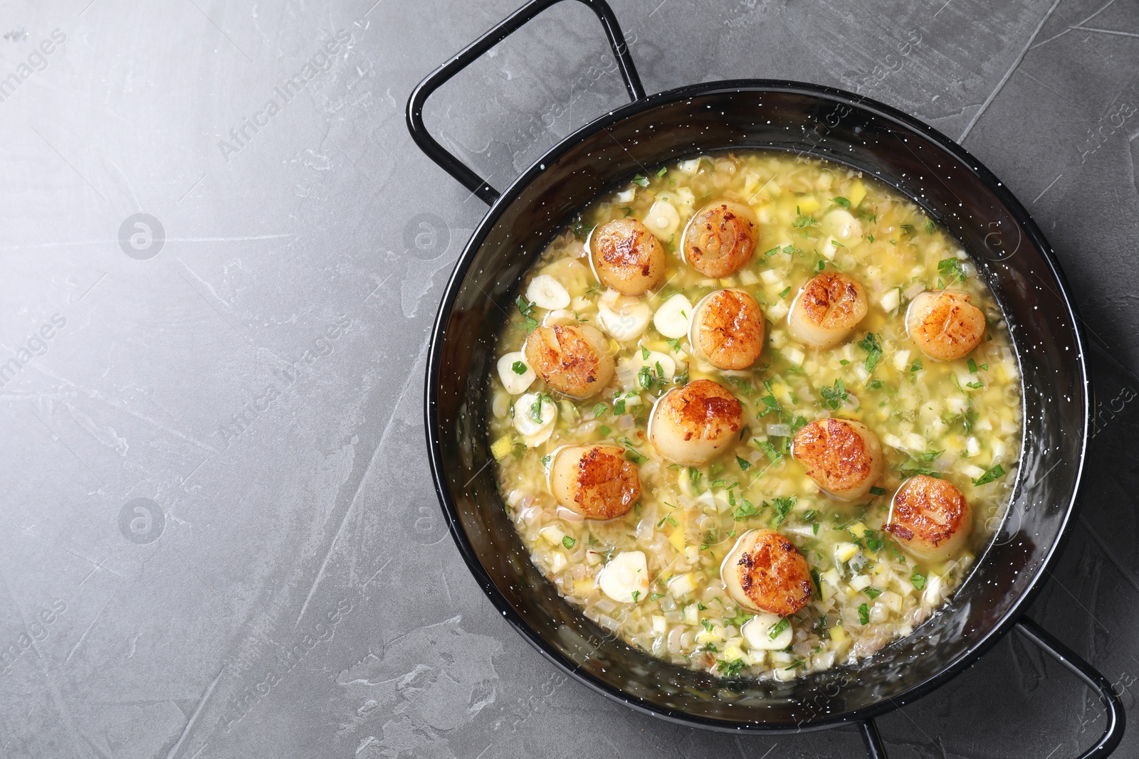 Photo of Fried scallops with sauce in dish on grey table, top view. Space for text