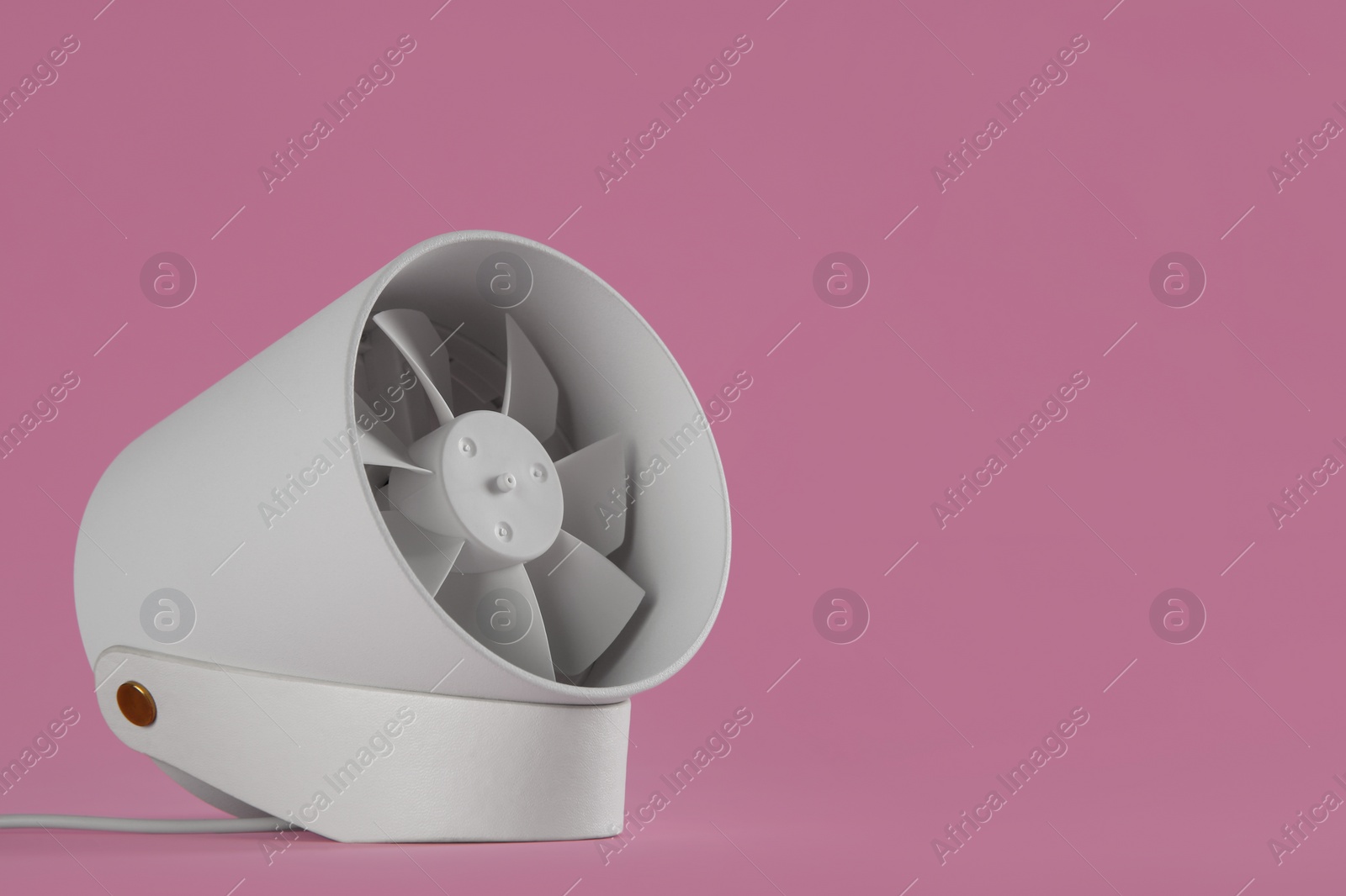 Photo of Modern electric fan on pink background. Space for text