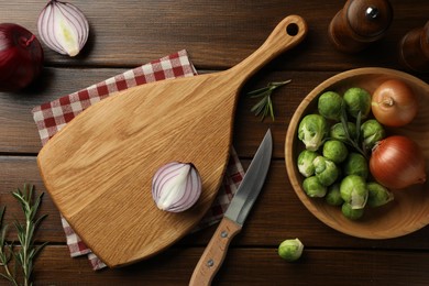 Photo of Cutting board with different vegetables, rosemary and knife on wooden table, flat lay