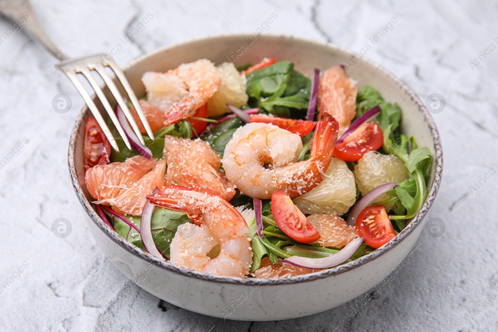 Photo of Delicious pomelo salad with shrimps served on white textured table, closeup