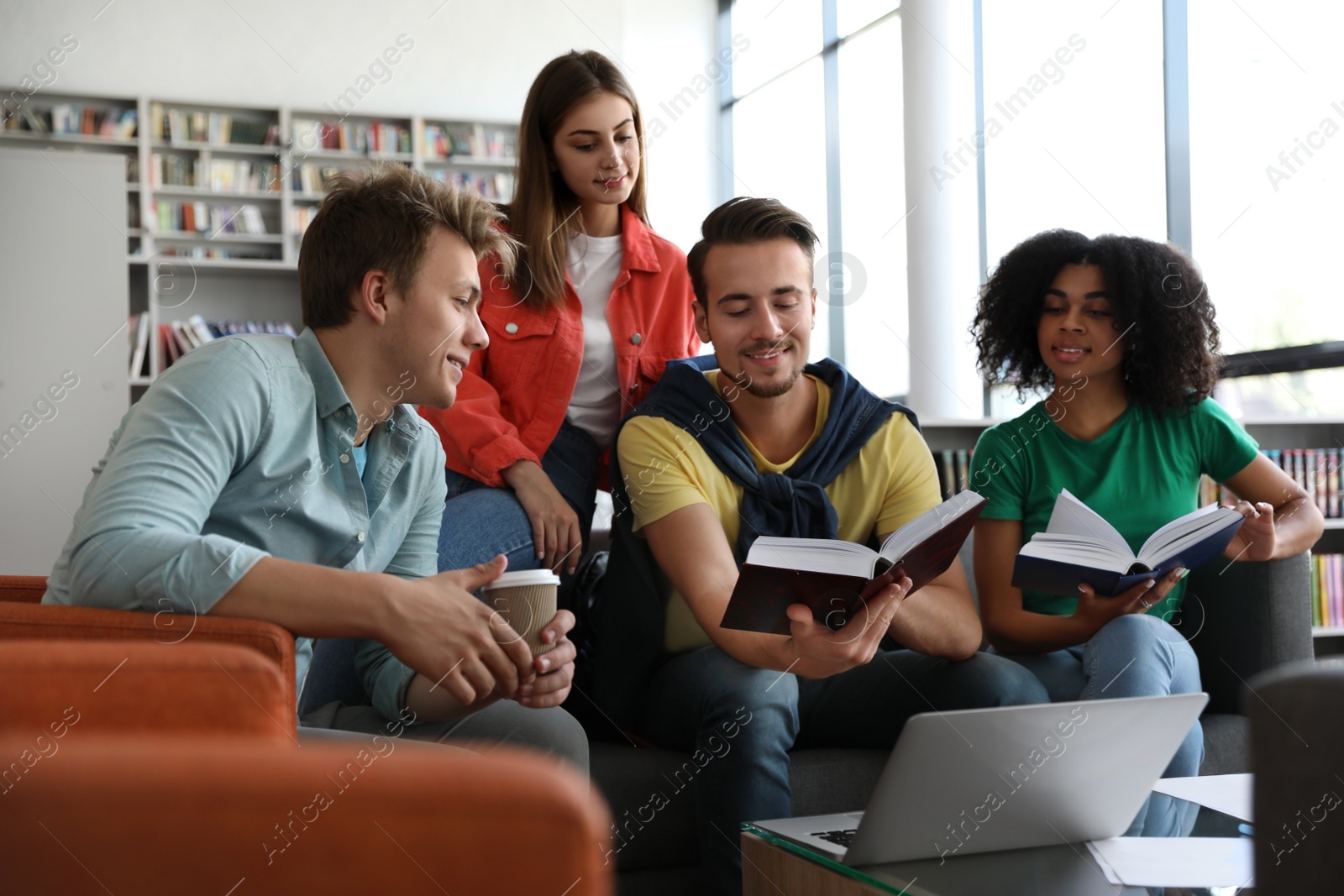 Photo of Group of young people studying at table in library