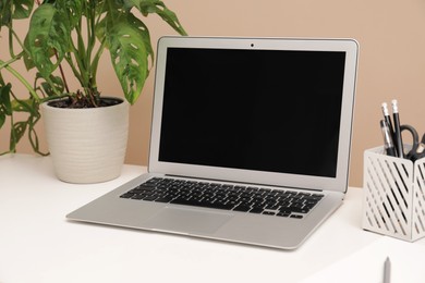 Photo of Cozy workplace with laptop and stationery on desk. Home office