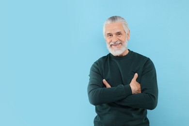 Photo of Portrait of handsome senior man on light blue background. Space for text