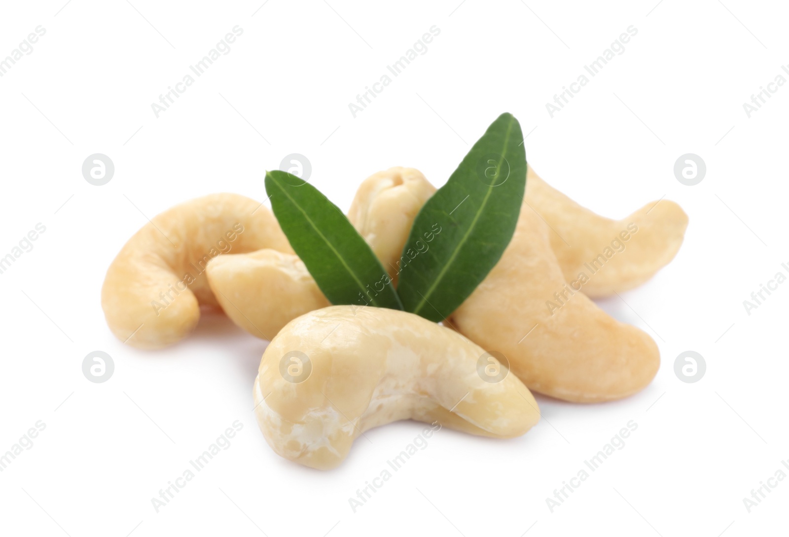 Photo of Pile of tasty organic cashew nuts and green leaves isolated on white, closeup