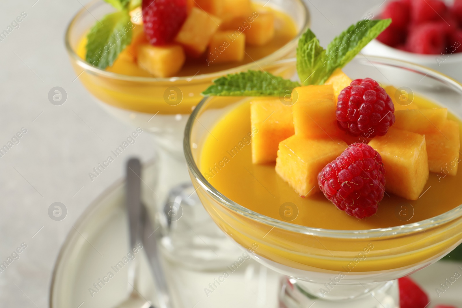 Photo of Delicious panna cotta with mango and raspberries, closeup