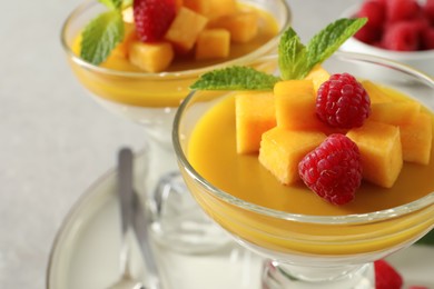 Photo of Delicious panna cotta with mango and raspberries, closeup
