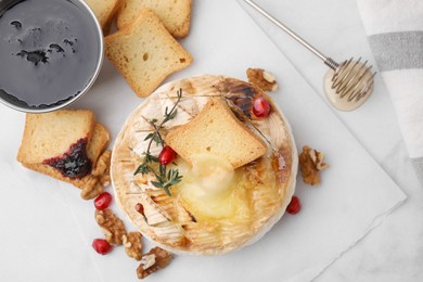 Flat lay composition with tasty baked camembert on white marble table