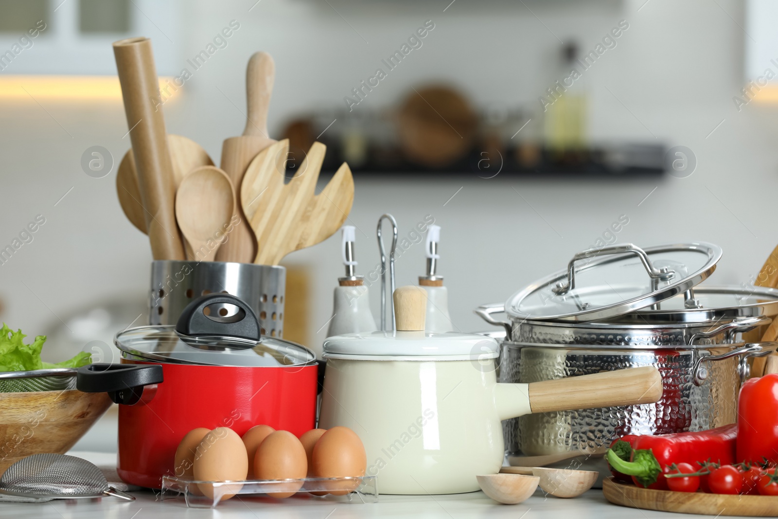 Photo of Set of cooking utensils and products on white table against blurred background