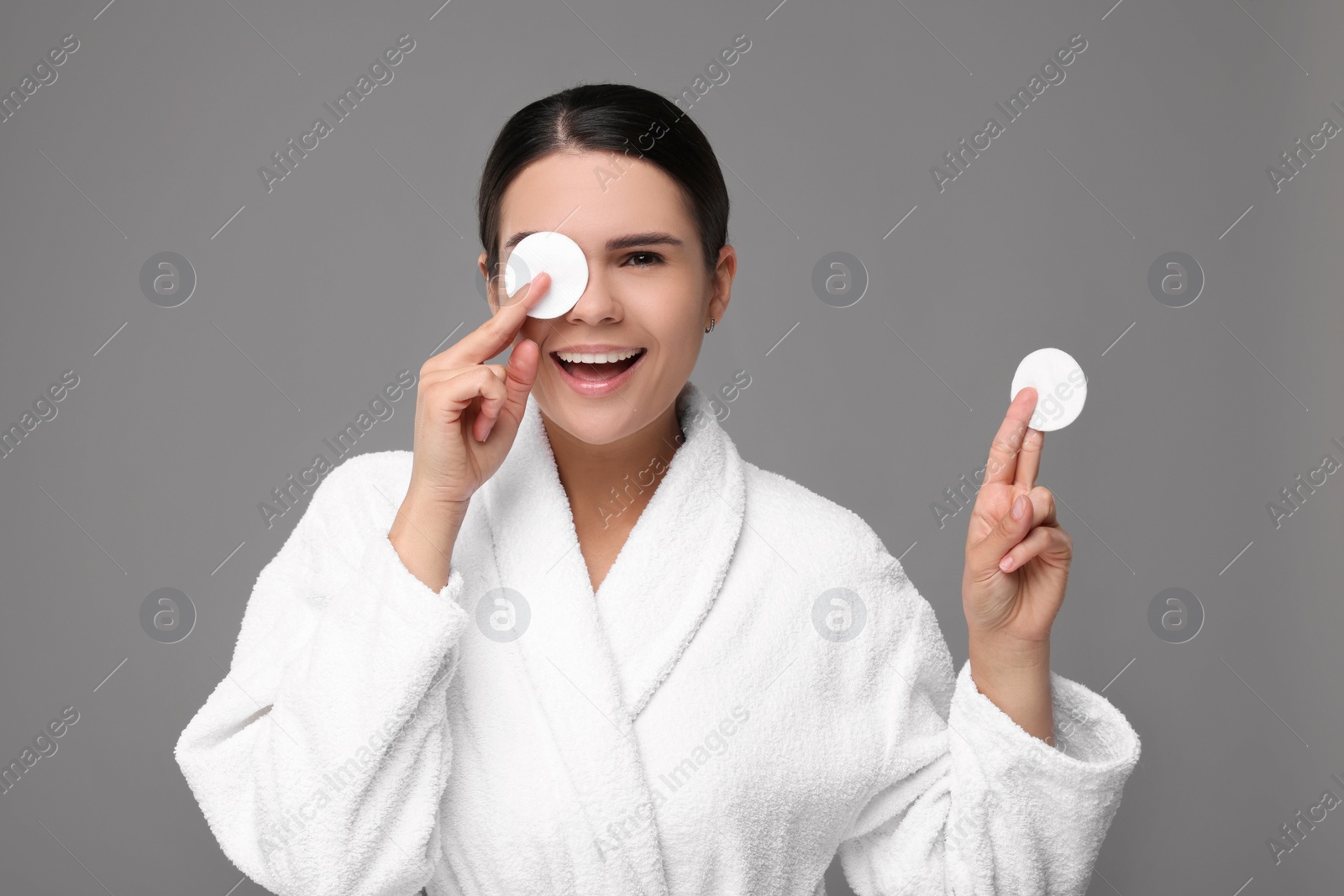 Photo of Young woman with cotton pads on grey background