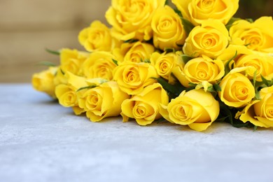 Beautiful bouquet of yellow roses on light table