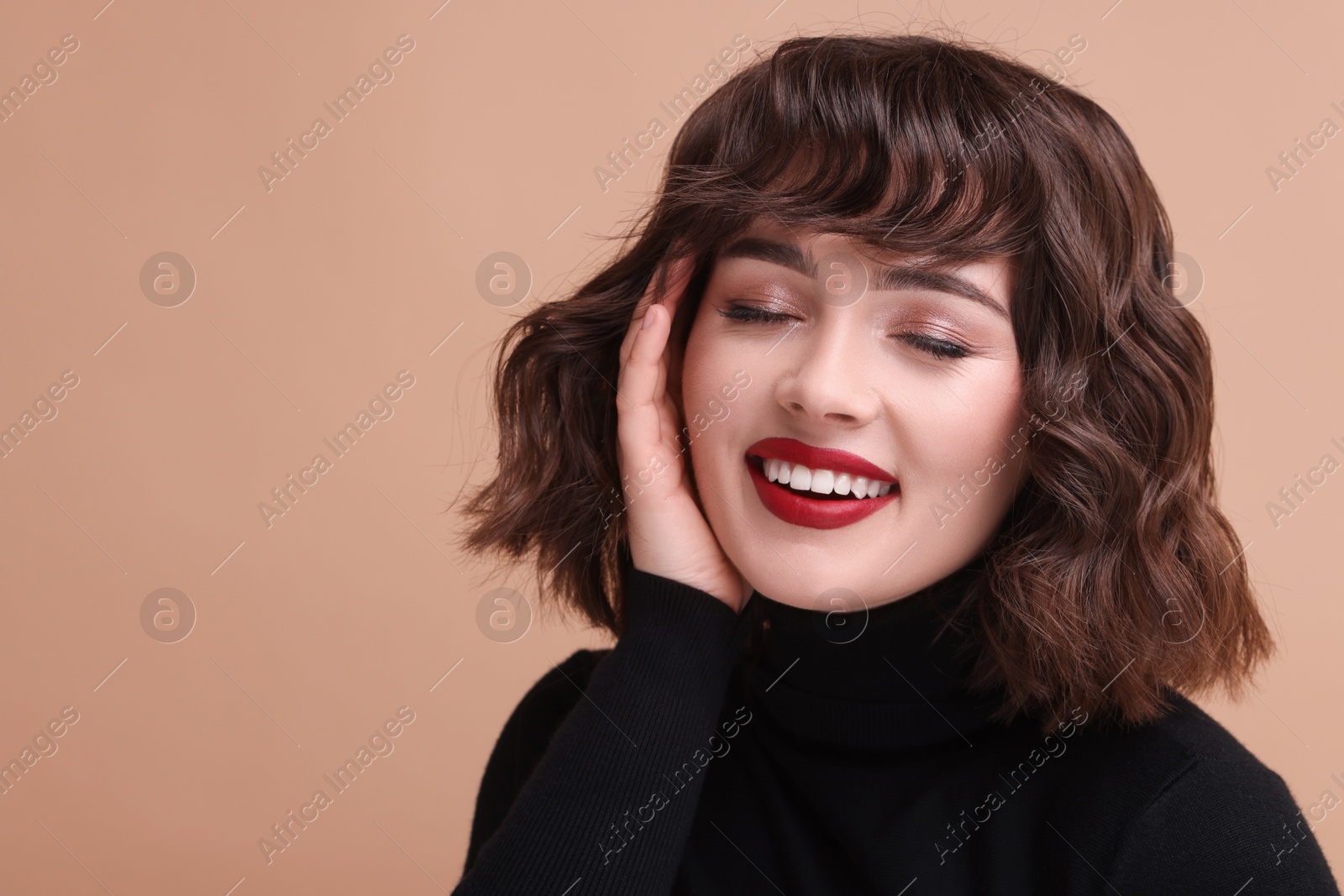 Photo of Portrait of beautiful young woman with wavy hairstyle on beige background. Space for text