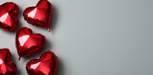 Photo of Red heart shaped balloons on grey background, space for text. Valentine's Day celebration