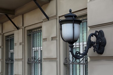 Photo of Elegant street lamp on building wall, space for text