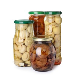 Photo of Jars with marinated mushrooms on white background