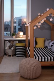 Stylish child room interior with comfortable house bed and toys