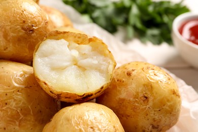 Photo of Tasty whole baked potatoes on table, closeup