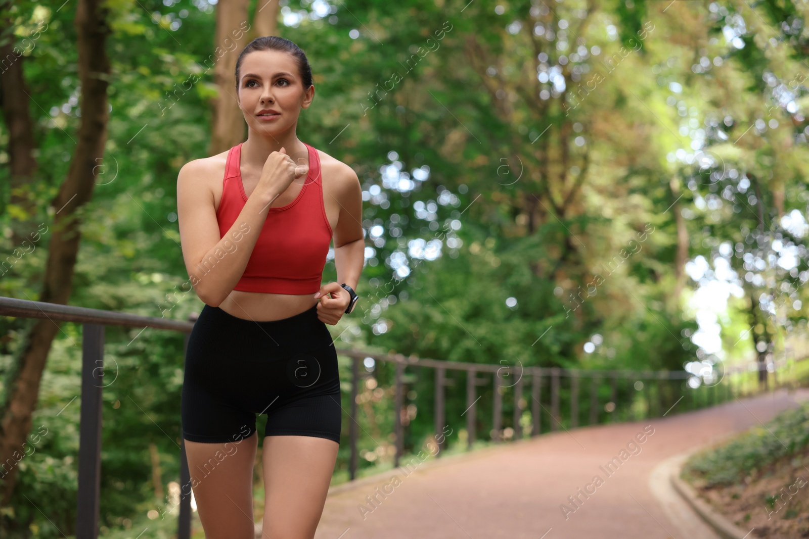 Photo of Beautiful woman in sportswear running in park. Space for text