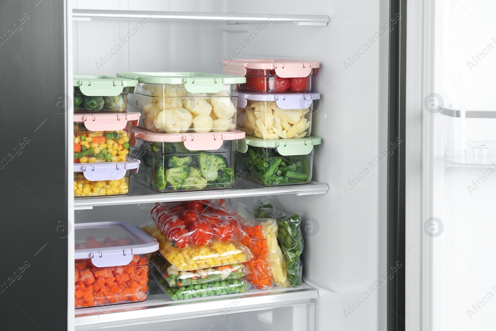 Photo of Plastic bags and containers with different frozen vegetables in refrigerator