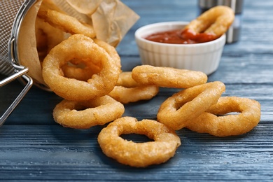 Photo of Onion rings served on wooden table, closeup