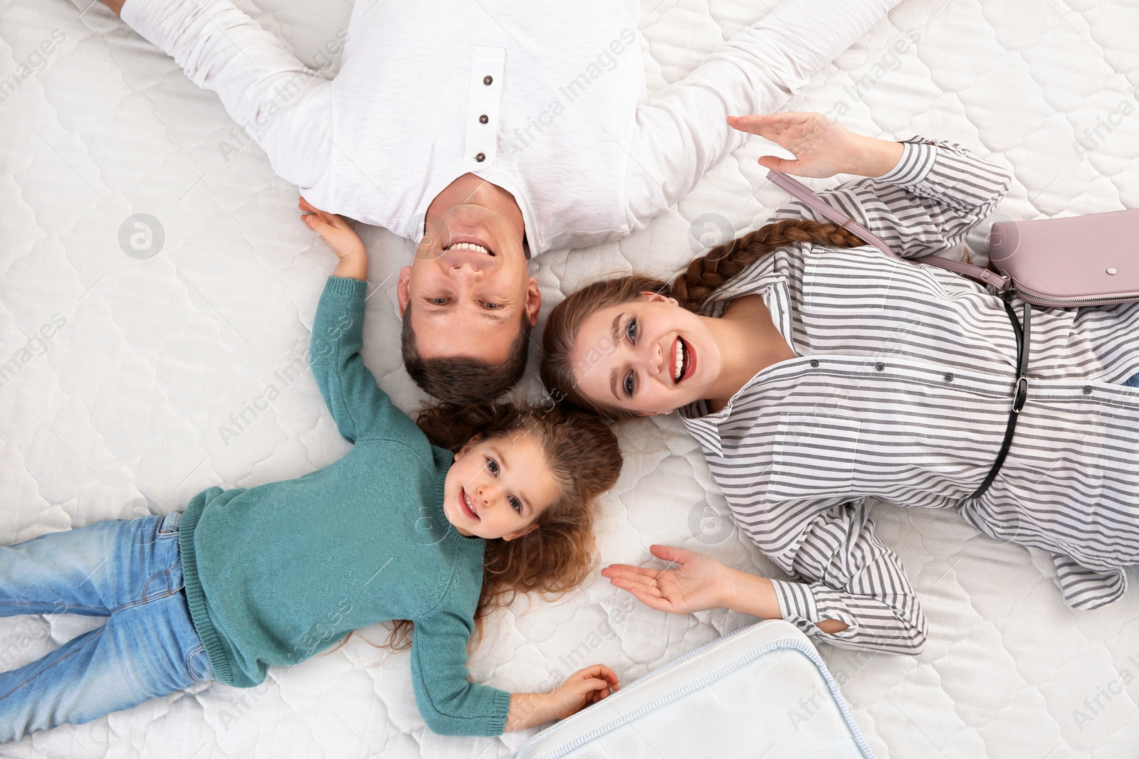 Photo of Happy family testing mattress in store, top view