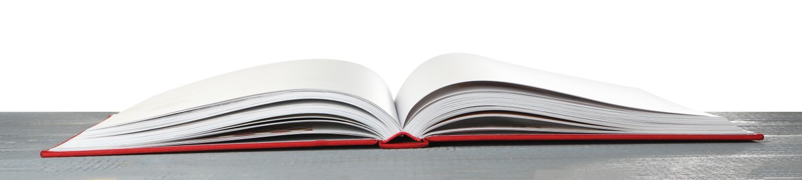 Photo of Open book with red cover on wooden table against white background