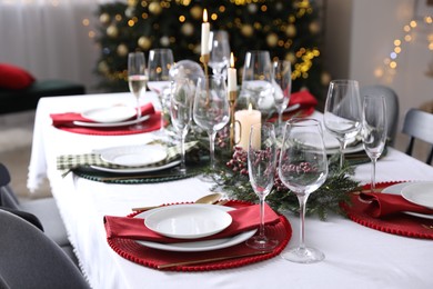 Photo of Christmas table setting with festive decor and dishware indoors