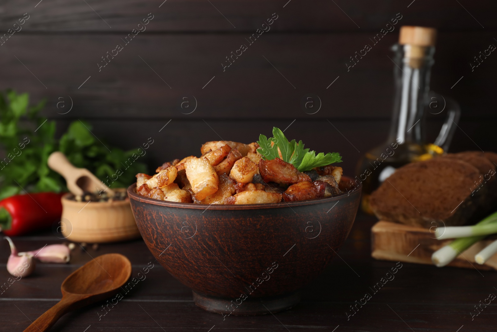 Photo of Tasty fried cracklings on wooden table. Cooked pork lard