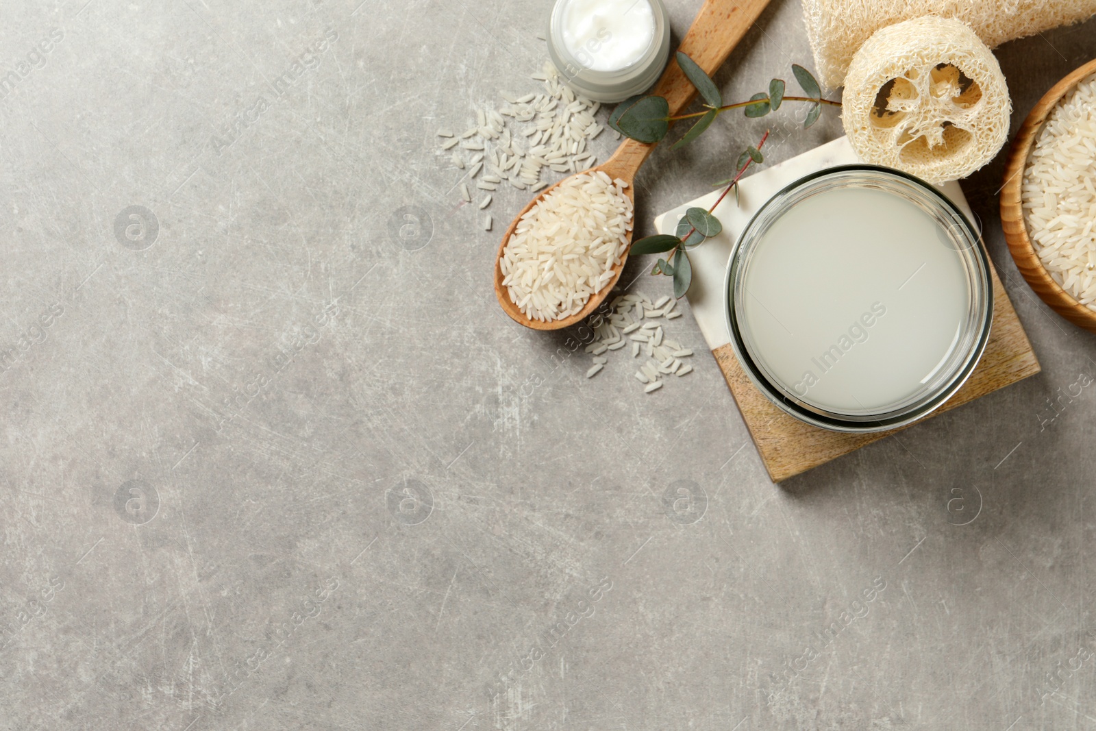 Photo of Flat lay composition with natural rice water on light grey table. Space for text